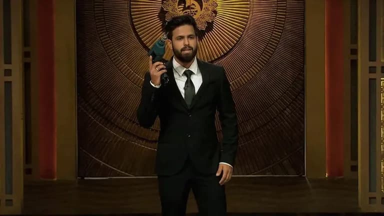 Siddharth Gupta presenting a product on Shark Tank India, wearing a black suit and holding a blue drill innovation