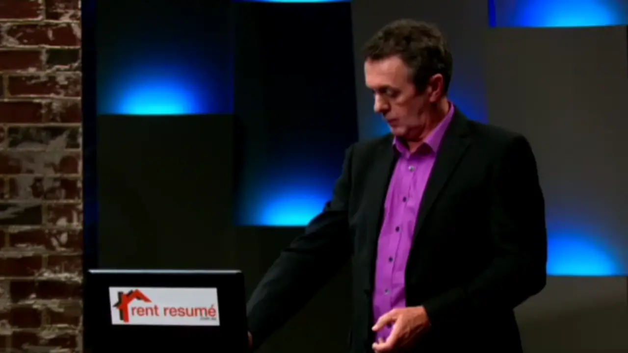 Darren Smith presenting Rent Resumé on Shark Tank Australia, standing beside a screen with the company logo