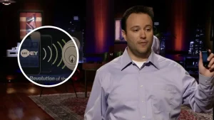 Phil Dumas presenting UniKey smart lock technology on Shark Tank, holding a smartphone during his pitch.