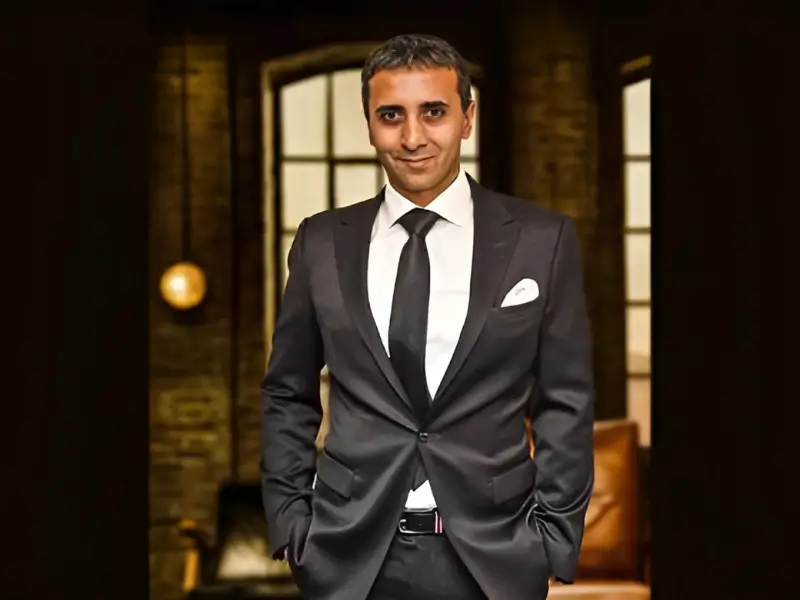Alex Buzaianu, founder of Temporary Forevers, in a black suit on the Dragons' Den set