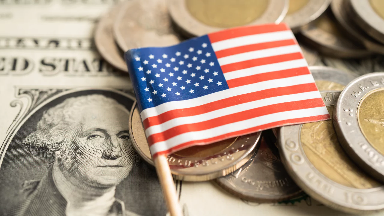 Close-up of U.S. dollar bill, coins, and American flag symbolizing millionaire growth in 2024