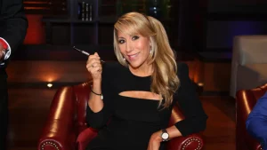 Lori Greiner sitting in Shark Tank studio holding a pen, sharing tips to get products into major retail stores like Target and Walmart
