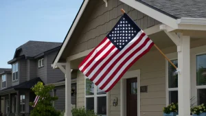 American flag hanging in front of a suburban home, symbolizing the U.S. housing market rebound in 2025.