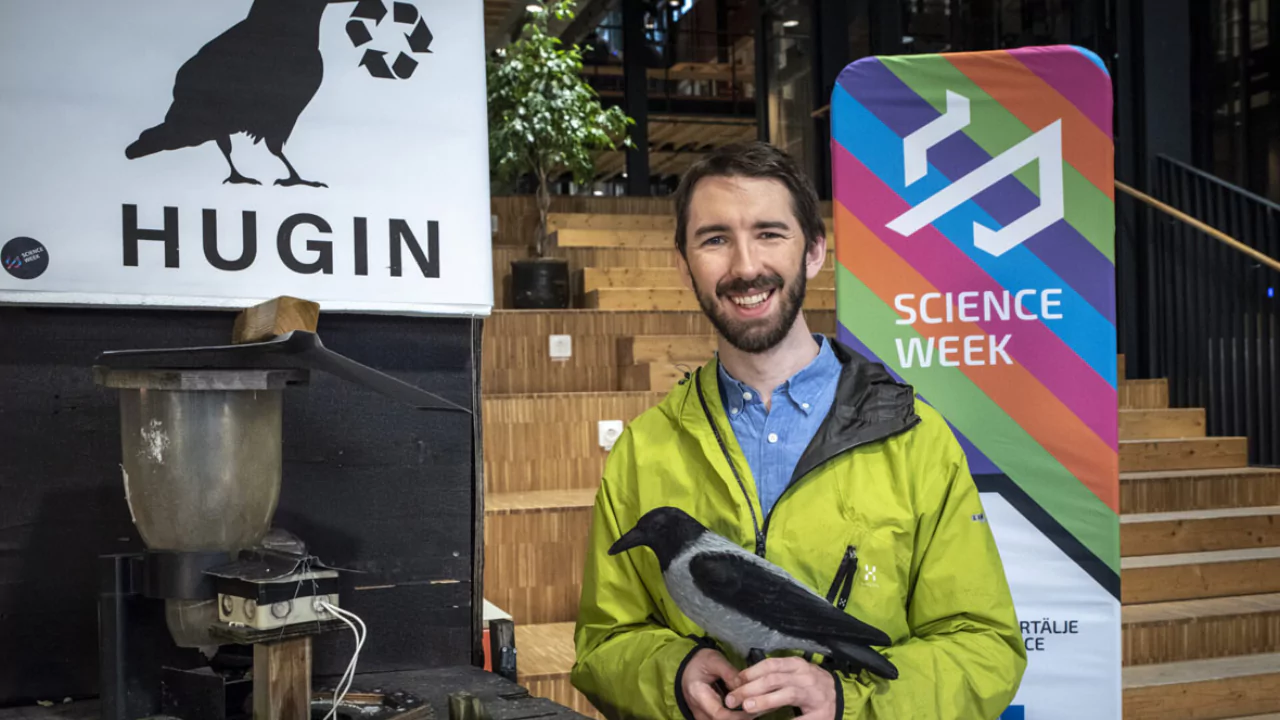Christian Günther-Hanssen, founder of Corvid Cleaning, holding a crow model next to the litter-collecting machine at Science Week in Södertälje, Sweden.
