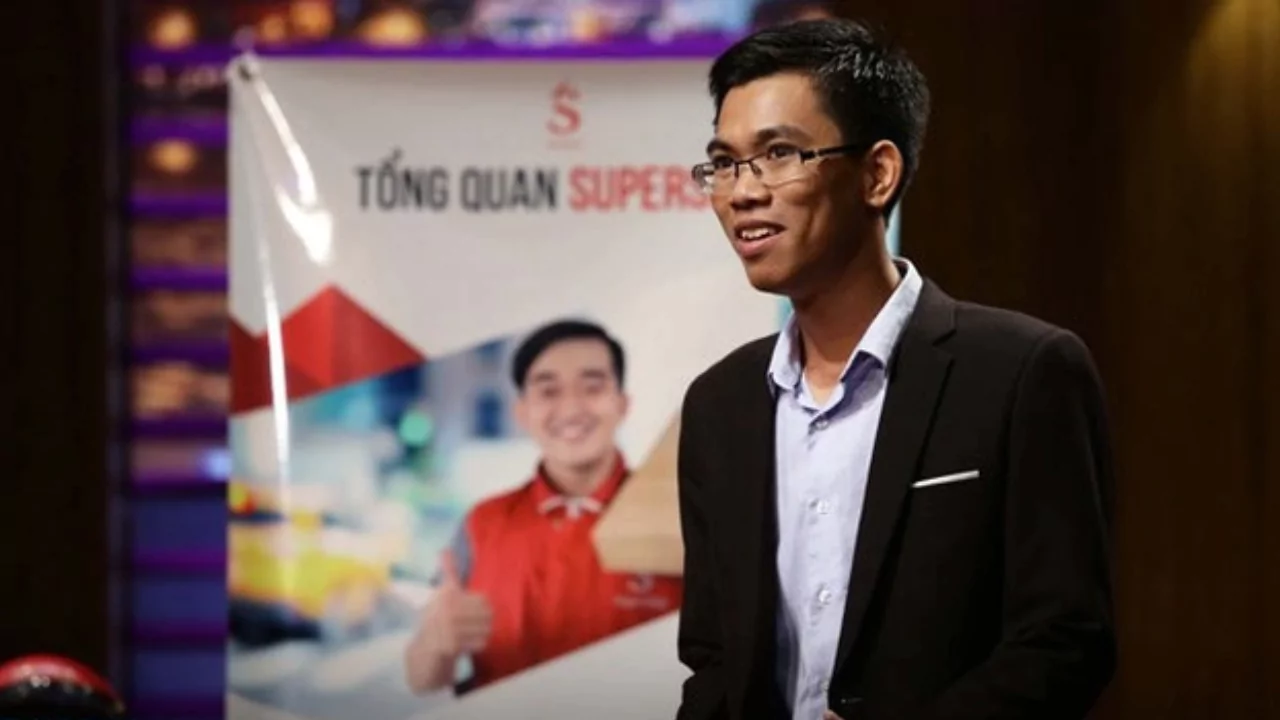 Founder of SuperShip pitching his delivery startup on Shark Tank Vietnam with a branded SuperShip banner in the background