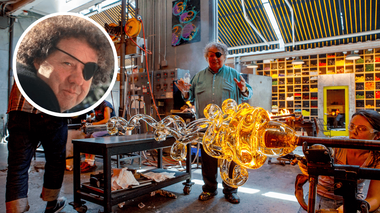 Dale Chihuly, the blind glassblower, directing a glass art team in his studio with a glowing sculpture in progress