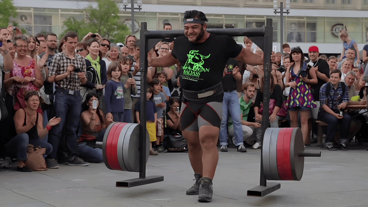 Patrik Baboumian performing a record-breaking 1,200-pound vegan strongman yoke carry during a public event